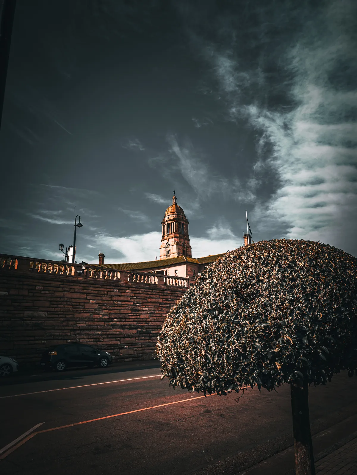 The Union Buildings clock tower under a dark teal sky, by Tha'Bang Studios